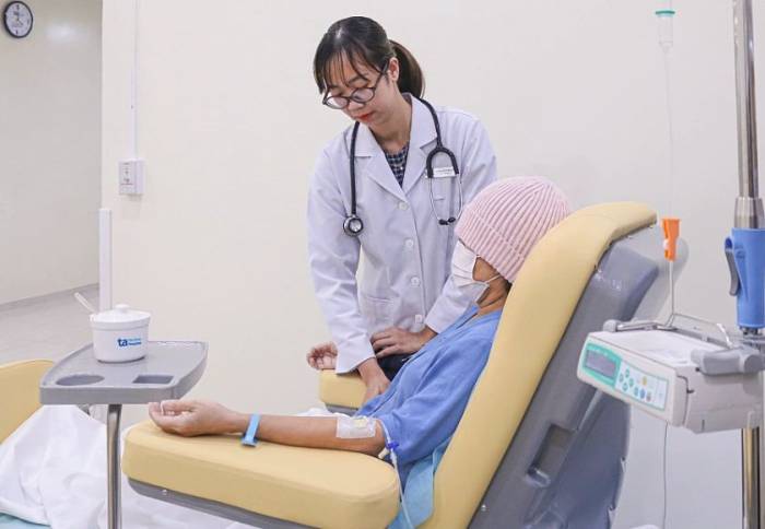 Bác sĩ Vân kiểm tra sức khỏe cho bà Hân trong quá trình truyền thuốc hóa trị. Ảnh: Bệnh viện Đa khoa Tâm Anh