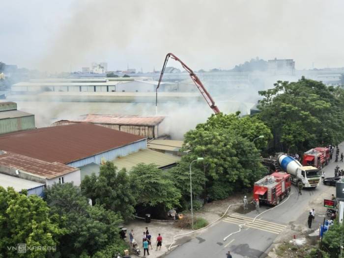 Cảnh sát dùng vòi của xe bơm bê tông để dập lửa. Ảnh: Gia Chính