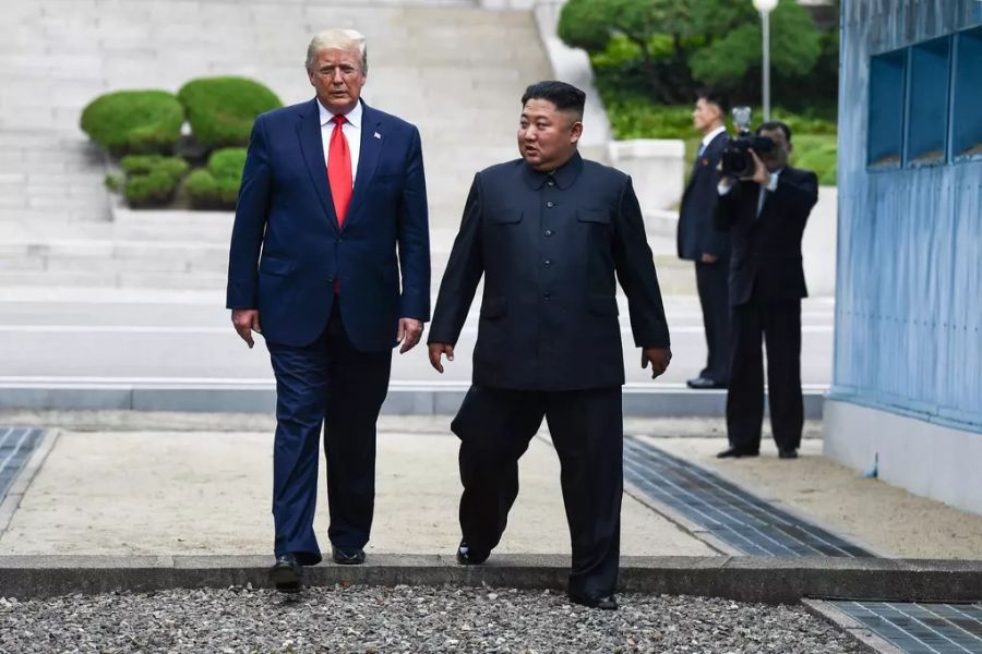 Tổng thống Mỹ Donald Trump (trái) và lãnh đạo Kim Jong-un bước qua giới tuyến liên triều tại Bàn Môn Điếm ngày 30/6/2019. Ảnh: AFP