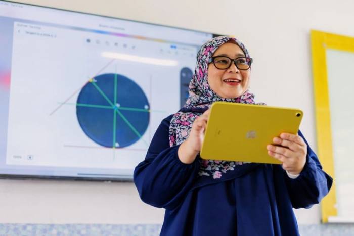 Cô Fazlina Ibrahim sử dụng iPad để trình chiếu bài giảng trên màn hình tương tác. Ảnh: TN