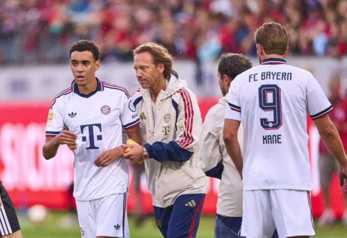 Jamal Musiala được bác sĩ dìu rời sân sau khi ngã gục trên sân trong trận giao hữu Heidenheim – Bayern Munich trên sân Voith, Heidenheim, Đức ngày 18/8/2026. Ảnh: EyesWideOpen