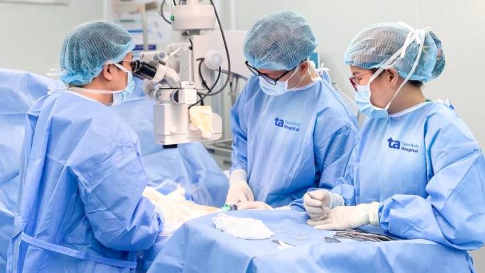Bác sĩ Huy (ngoài cùng bên trái) phẫu thuật micro-TESE tìm tinh trùng cho anh Moa. Ảnh: Bệnh viện Đa khoa Tâm Anh
