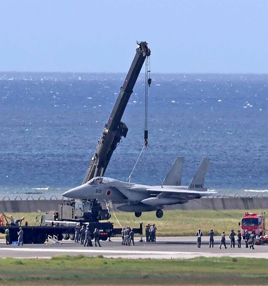 Cần cẩu đưa chiếc F-15J gặp sự cố khỏi đường băng ở sân bay Naha, tỉnh Okinawa, Nhật Bản ngày 18/8. Ảnh: Kyodo
