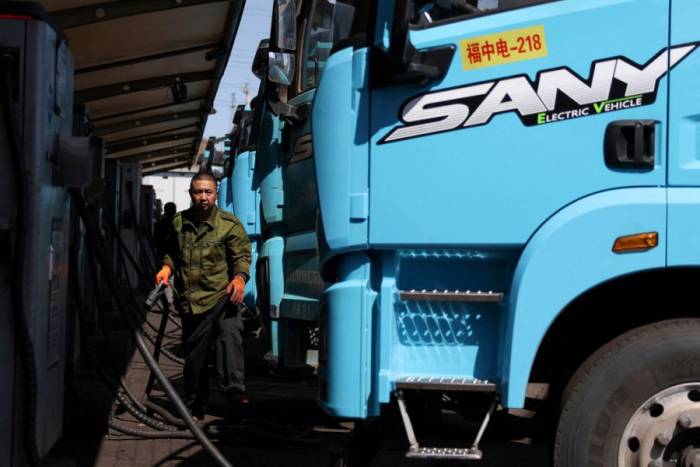 Một tài xế sạc xe tải điện tại trạm sạc ở Đường Sơn, tỉnh Hà Bắc, Trung Quốc, ngày 1/4. Ảnh: Reuters
