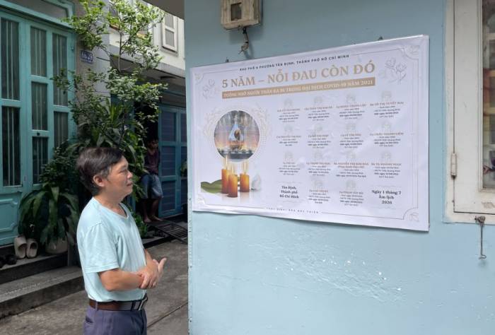 Ông Đào Đức Thiện trước tấm bảng tưởng nhớ 14 người đã mất ở hẻm 68 Trần Quang Khải, phường Tân Định, TP HCM, chiều 13/8. Ảnh: Ngọc Ngân