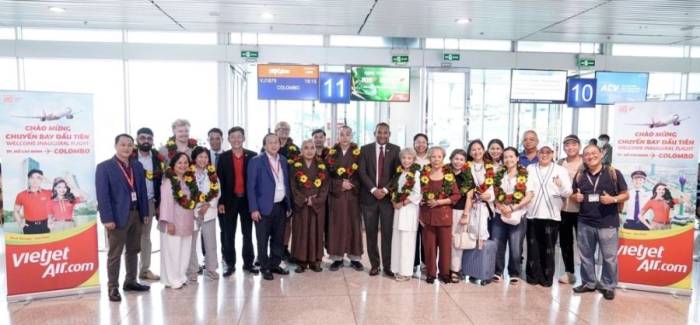 Lãnh đạo Vietjet tặng hoa và chào đón hành khách trên chuyến bay đầu tiên. Ảnh: Tài Nguyễn