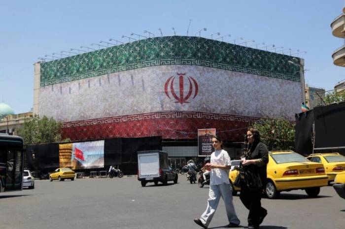 Màn hình hiển thị quốc kỳ Iran tại Quảng trường Enghelab ở Tehran, Iran ngày 15/6. Ảnh: AFP