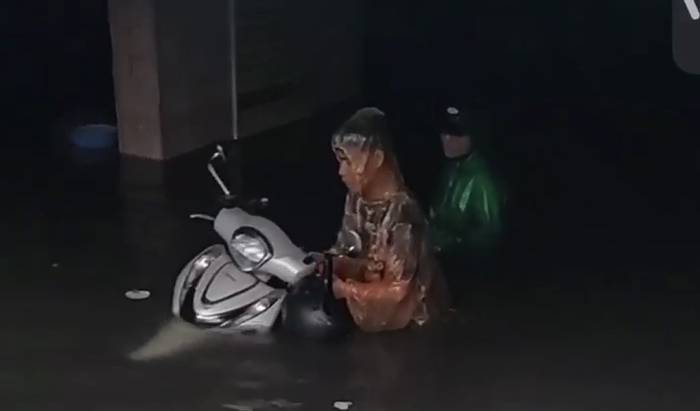 Dân chung cư Dầu khí Hưng Bình, phường Thành Vinh lội nước cứu xe máy sau khi hầm bị ngập sáng 19/9. Ảnh: Hồng Hạnh