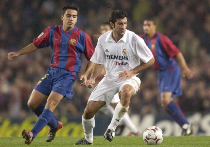Luis Figo (phải) đối đầu Xavi trong trận Barca - Real Madrid trên sân Camp Nou, Barcelona, Tây Ban Nha vào tháng 11/2002. Ảnh: Reuters