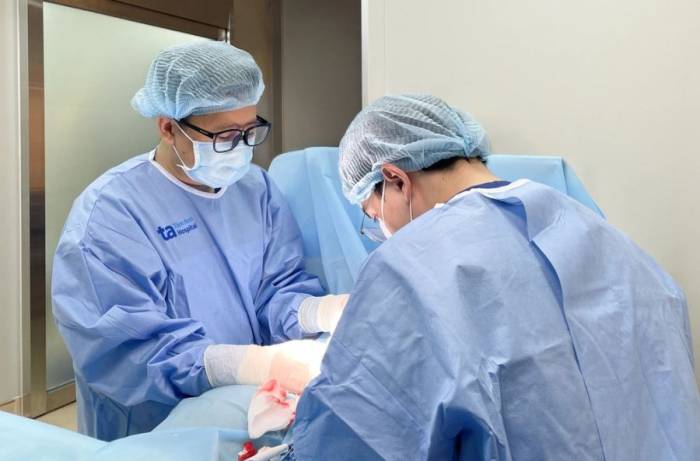 Bác sĩ Huy (trái) đang chọc hút tinh trùng từ mào tinh qua da cho bệnh nhân. Ảnh: Bệnh viện Đa khoa Tâm Anh