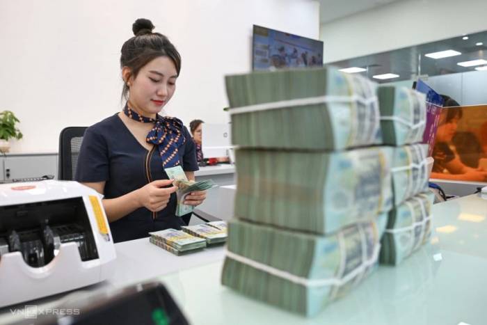 Nhân viên đang đếm tiền tại quầy giao dịch của một ngân hàng ở Hà Nội. Ảnh: Giang Huy