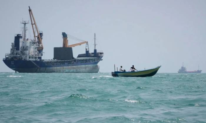 Xuồng máy đi qua gần tàu hàng neo đậu ngoài khơi thành phố cảng Bandar Abbas của Iran, ven eo biển Hormuz ngày 6/9. Ảnh: AP