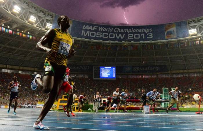 VĐV Jamaica Usain Bolt về nhất chung kết 100m giải vô địch điền kinh thế giới trên sân Luzhniki, Moscow ngày 11/8/2013 khi tia sét xé ngang bầu trời. Ảnh: AFP
