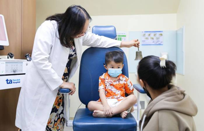 GS Chung Thủy lắc chuông, kiểm tra tiếp nhận âm thanh của bé Long sau một tháng cấy điện cực. Ảnh: Bệnh viện cung cấp