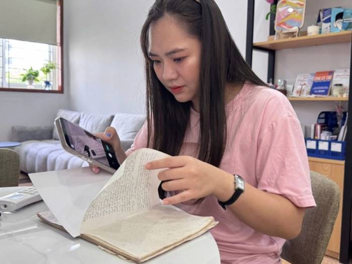 Chị Nhung đọc và chụp lại nhật ký cả bác để sao lưu, tháng 8/2026. Ảnh: Phạm Nga