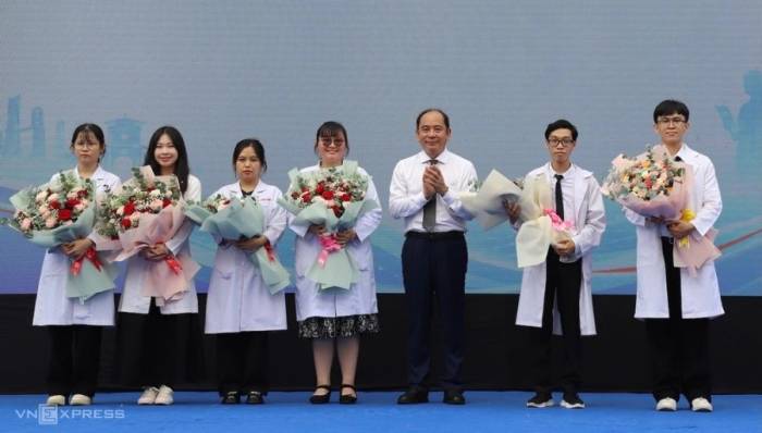 Giám đốc Sở Y tế TP HCM Tăng Chí Thượng tặng hoa 6 bác sĩ khóa 4 chọn về làm việc tại trạm y tế ngay sau khi kết thúc khóa thực hành. Ảnh: Song Khuê