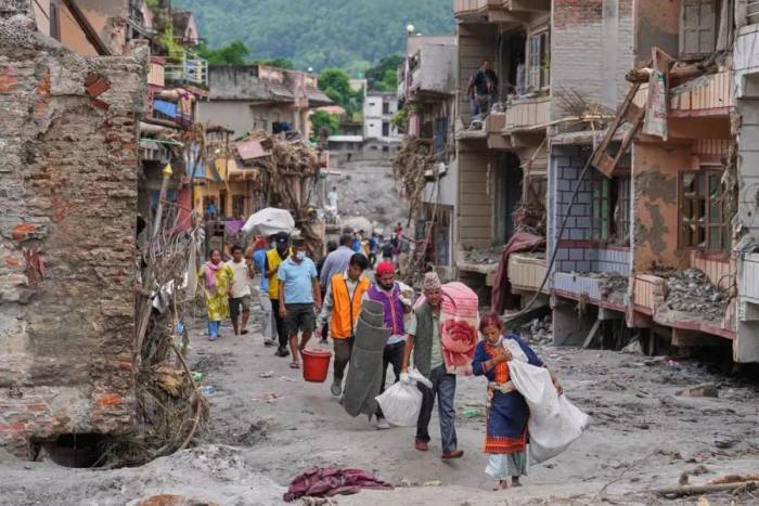 Người dân ở làng Devighat, huyện Nuwakot, quay lại nhà lấy đồ sau trận lũ quét  ngày 27/8. Ảnh: AP