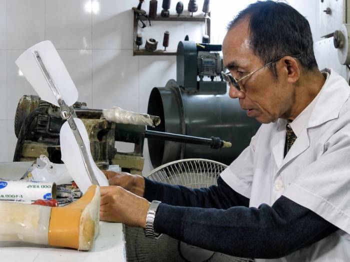 Bác sĩ Lê Thành Đô, kiểm tra nẹp trên chân giả cho người bệnh tại xưởng sản xuất ở ngõ Gốc Đề, Hà Nội. Ảnh: Nhân vật cung cấp