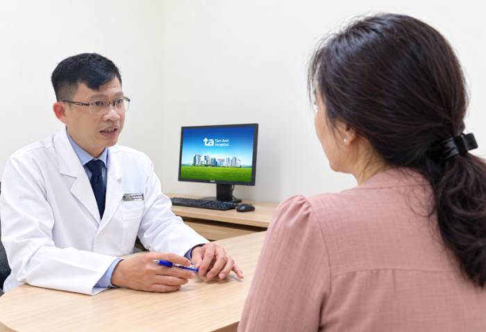 Bác sĩ Tấn hướng dẫn người bệnh cách tự kiểm tra ngực trong ngày tái khám. Ảnh: Bệnh viện cung cấp