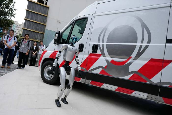 Robot hình người đứng cạnh xe cứu thương dành cho robot của GMO Internet tại Tokyo. Ảnh AP