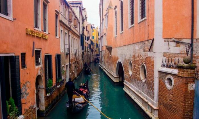 Du khách đi thuyền truyền thống tên Gondola, trên kênh đào ở Venice. Ảnh: Hưng Quân