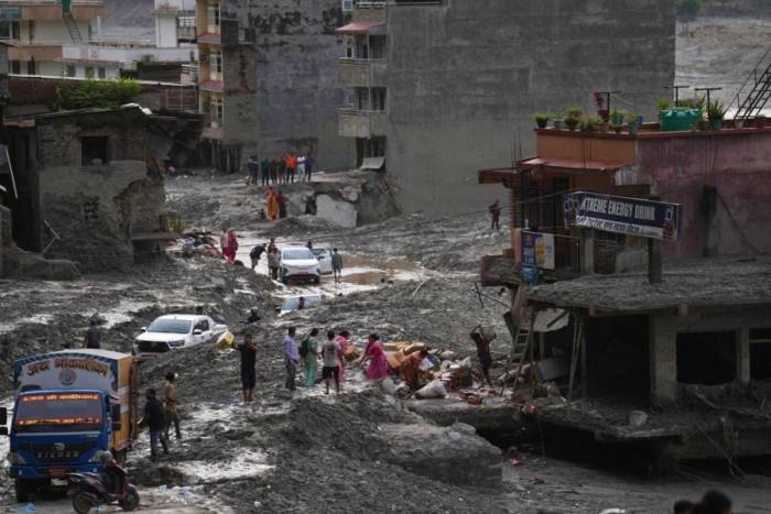 People salvage their belongings from a building damaged by flash flooding in Nuwakot district of Nepal, Tuesday, Sept. 1, 2026. (AP Photo/Rajesh Kumar Singh)