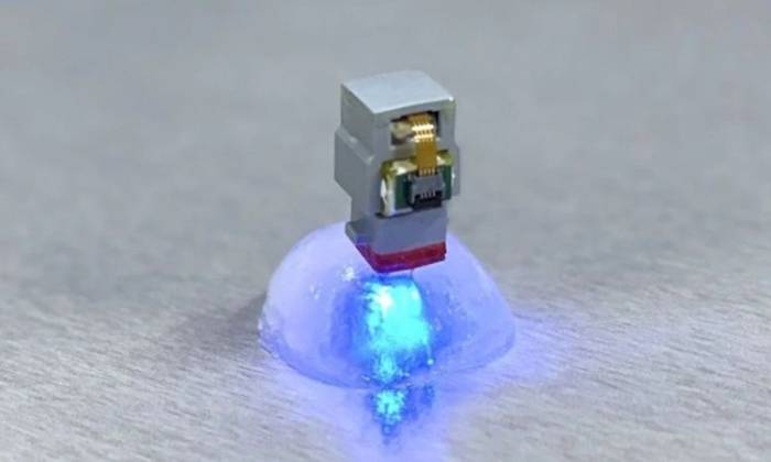 Thiết bị cấy ghép phát ra ánh sáng xanh khi kích thích quang học. Ảnh: KAIST