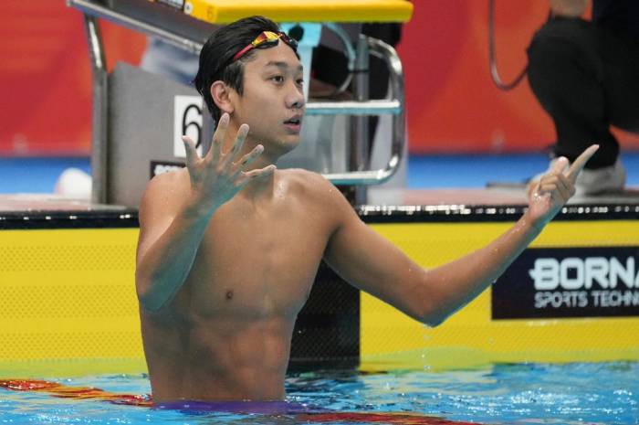 Kình ngư Trung Quốc Zhang Zhansuo đếm huy chương sau khi về nhất ở bơi 400m tự do nam ASIAD 2026, tại Cung thể thao dưới nước Tokyo, Nhật Bản ngày 25/9/2026. Ảnh: AP