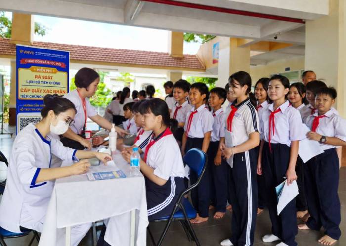 Nhân viên VNVC phối hợp y tế địa phương và nhà trường khám sức khỏe, hướng dẫn học sinh cách thức rà soát lịch sử tiêm chủng tại Trường THCS Phú Lợi, TP HCM. Ảnh: Trí Nhiên