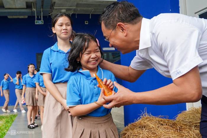 Bí thư Thành ủy Đà Nẵng Lê Ngọc Quang phát kem cho học sinh Trường Hy Vọng sau lễ chào mừng năm học mới. Ảnh: Nguyễn Đông