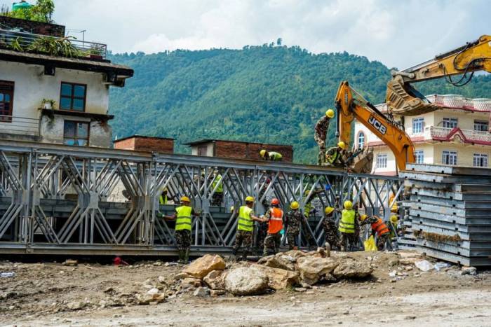 Quân đội Nepal đang lắp ráp một cây cầu thép mô-đun qua sông Tadi ở Devighat, Nuwakot, Nepal, hôm 7/9, trong nỗ lực tái thiết các khu vực bị lũ quét ảnh hưởng. Ảnh: AFP