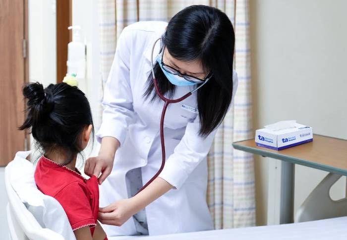 Bác sĩ Hy khám cho bé Vi trước khi xuất viện. Ảnh: Bệnh viện Đa khoa Tâm Anh