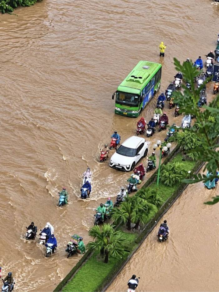 Người dân di chuyển khó khăn trên đường Tố Hữu, đoạn qua chung cư HH2D Dương Nội, phường Yên Nghĩa di ngập sâu, sáng 17/9. Ảnh: Quỳnh Mai