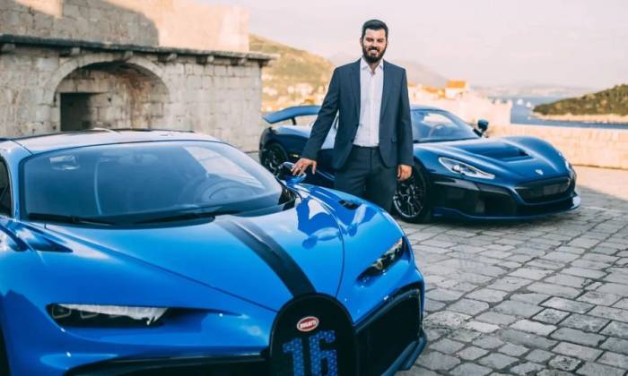 Mate Rimac đứng bên siêu xe Bugatti, phía sau là siêu xe Rimac. Ảnh: Rimac