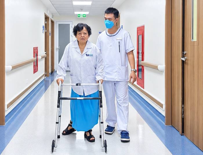 Bà Nhung tập đi lại sau phẫu thuật thay khớp gối trái. Ảnh: Bệnh viện Đa khoa Tâm Anh