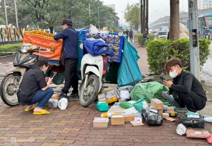 Shipper chờ khách nhận hàng tại phố Duy Tân, Cầu Giấy, Hà Nội, tháng 2/2024. Ảnh: Ngọc Thành