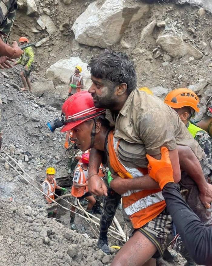 Công nhân thủy điện Nepal được nhân viên cứu hộ cõng khỏi khu vực bị vùi lấp. Ảnh: X/@RONBupdates