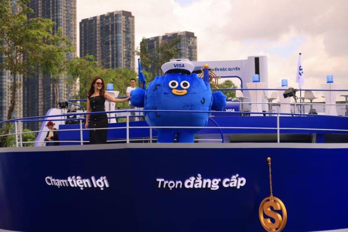 Người tham dự tham gia chụp hình trên mô hình thuyền. Ảnh: Sacombank