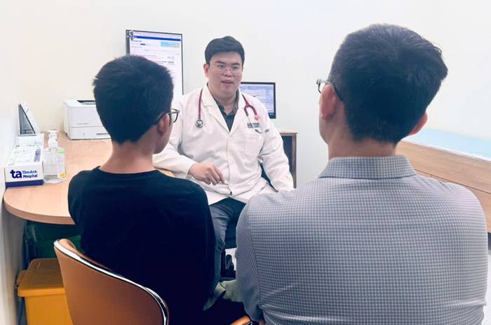 Khánh (bên trái) cùng phụ huynh tái khám với bác sĩ Sơn. Ảnh: Đinh Huệ