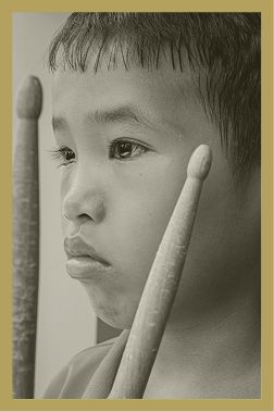 Bé trai cầm dùi trống