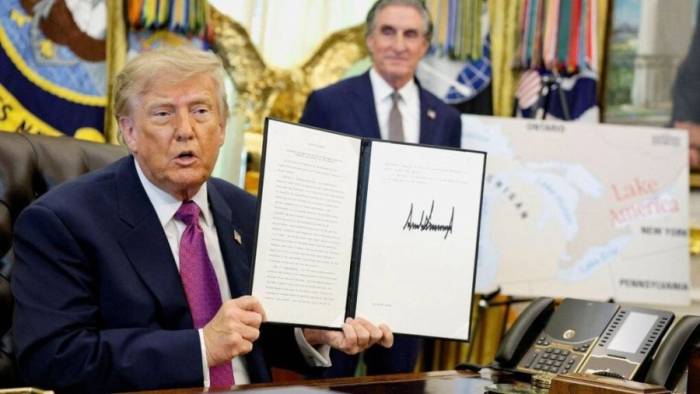 Tổng thống Trump ký sắc lệnh đổi tên bên cạnh tấm bản đồ có chữ hồ Mỹ ngày 27/8. Ảnh: Reuters