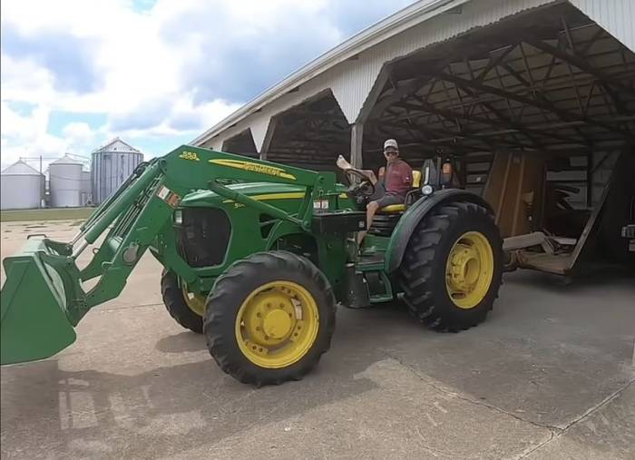Andy điều khiển xe máy xúc bằng chân trong một video đăng tải trên trang cá nhân. Ảnh: Harmless Farmer