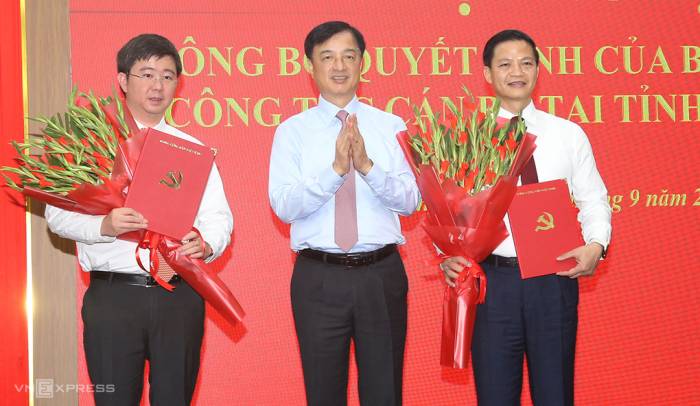 Trưởng ban Tổ chức Trung ương Nguyễn Duy Ngọc trao quyết định của Bộ Chính trị, tặng hoa chúc mừng cho ông Vương Quốc Tuấn (phải), Bí thư Tỉnh ủy và ông Bùi Hoàng Phương (trái) Phó bí thư Tỉnh ủy Quảng Trị, sáng 21/9. Ảnh: Đắc Thành