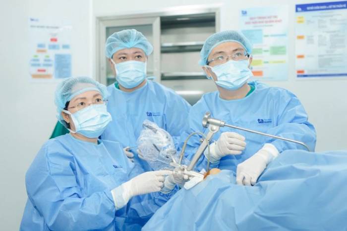 Bác sĩ Hằng (ngồi) đang phẫu thuật u nang dây thanh cho người bệnh. Ảnh minh họa: Bệnh viện Đa khoa Tâm Anh
