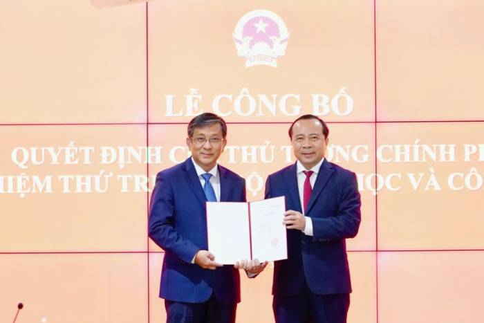 Bộ trưởng Vũ Hải Quân trao quyết định điều động, bổ nhiệm của Thủ tướng cho Thứ trưởng Trần Trung Tính. Ảnh: Thùy Linh