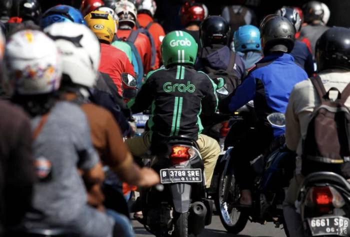 Một người lái xe Grab đang di chuyển trong giờ cao điểm ở Jakarta, Indonesia, ngày 18/7/2016. Ảnh: REUTERS/Iqro Rinaldi