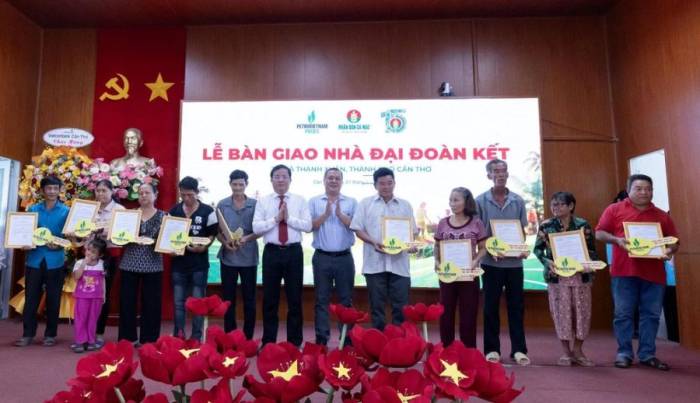 Lãnh đạo thành phố Cần Thơ và đại diện Phân Bón Cà Mau trao quyết định bàn giao cùng chìa khóa tượng trưng cho các hộ dân được nhận nhà Đại đoàn kết. Ảnh: PVCFC