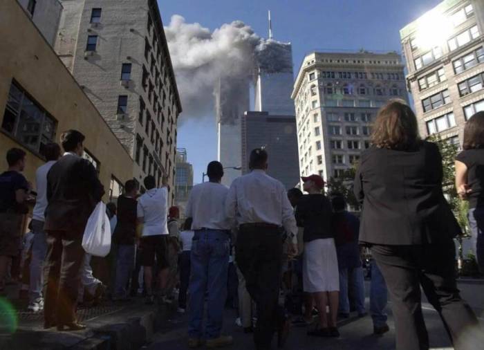 Người dân ở Hạ Manhattan quan sát khói bốc lên từ WTC tại New York ngày 11/9/2001. Ảnh: AP