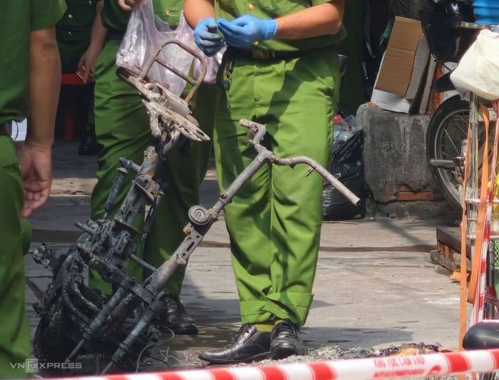 Xe máy trơ khung được cảnh sát đưa ra từ nhà cháy. Ảnh: Đình Văn