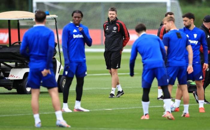 HLV Michael Carrick (áo đen) quan sát buổi tập của Man Utd tại trung tâm huấn luyện Trafford, Carrington, Anh ngày 9/9/2026. Ảnh: Reuters